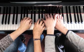 Piano joué par deux personnes